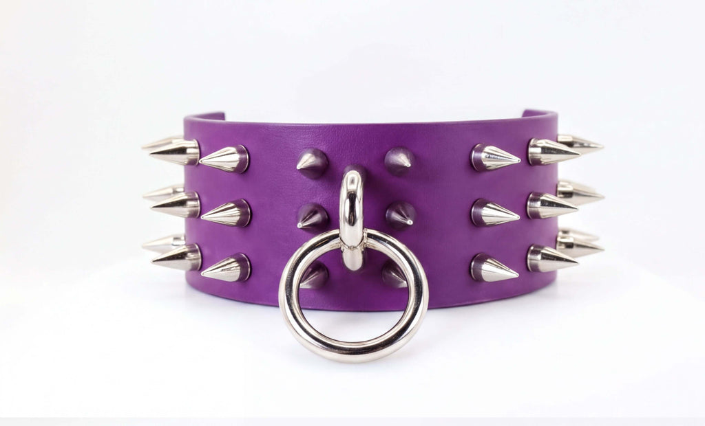 A purple leather choker necklace with silver spikes protruding from it.