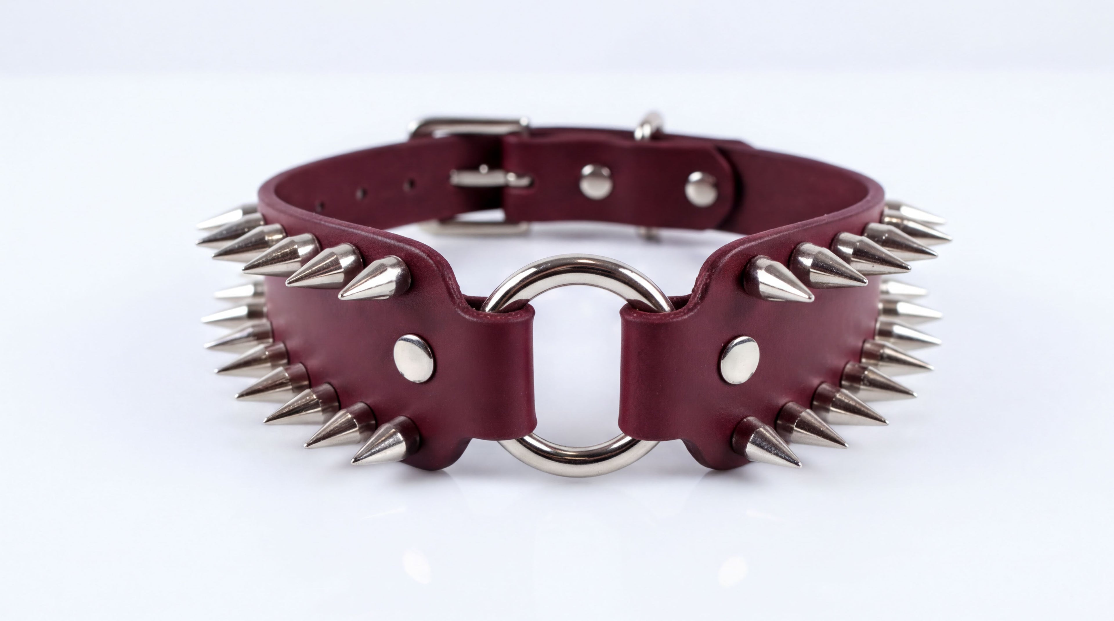 A burgundy leather choker necklace with spikes protruding from it.