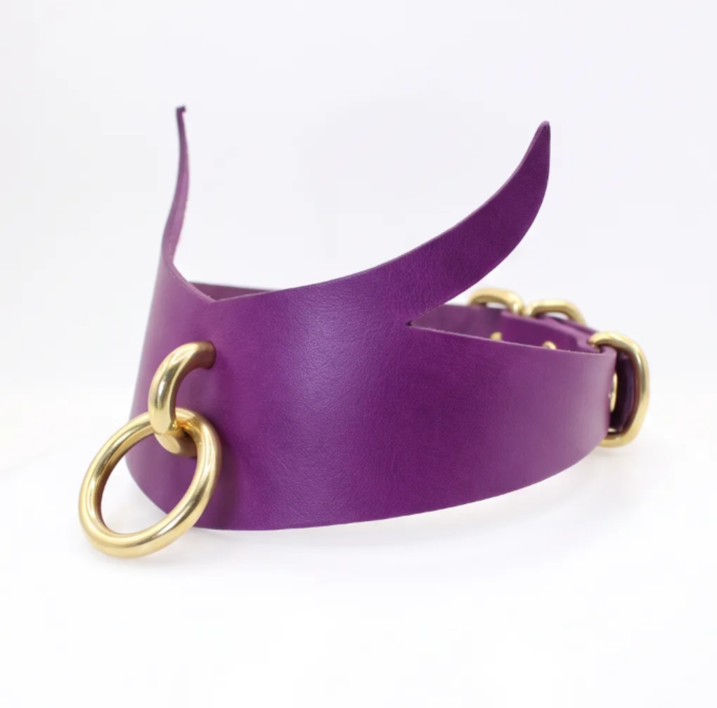 four leather choker necklaces with different colors and designs, including purple, green, black, and silver rings.
