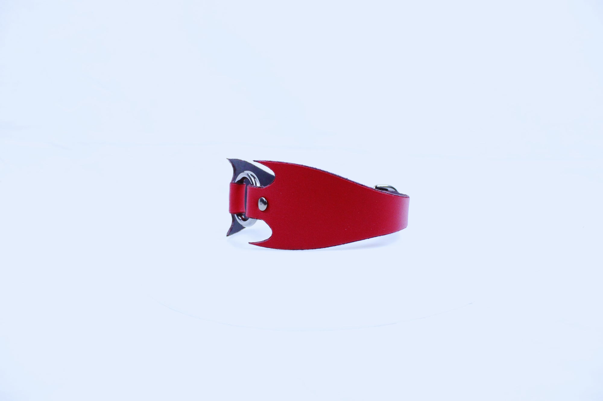 A red leather bracelet with a unique, curved design is shown against a plain white background.