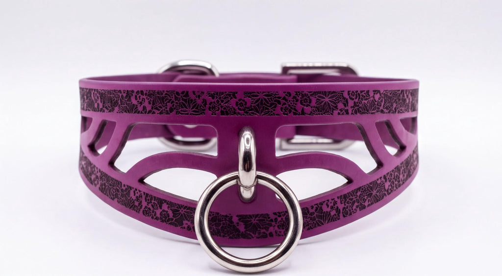 A purple leather choker collar with a metal ring and a decorative pattern on the surface.