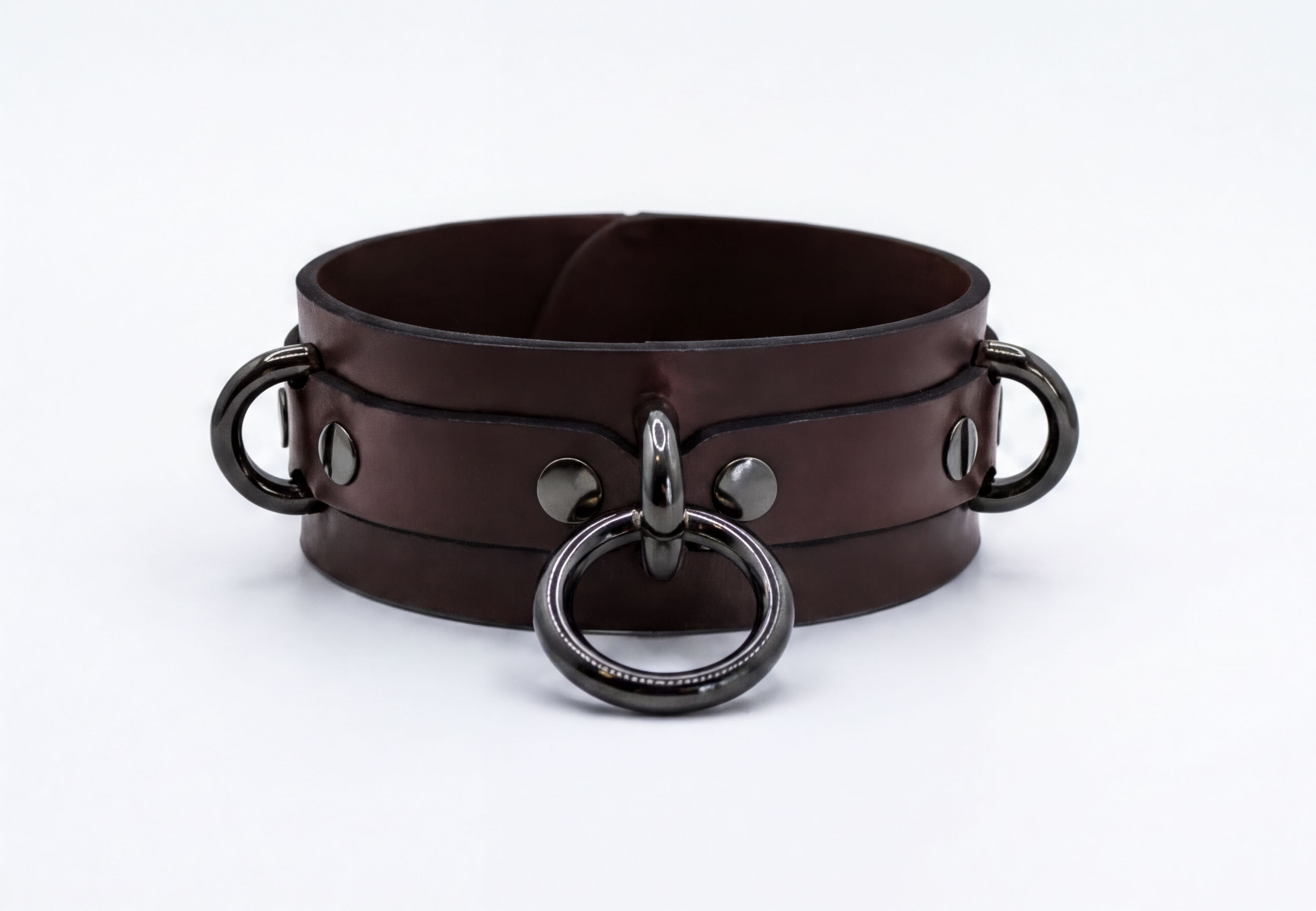 A brown leather choker collar with metal rings and buckles.