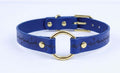 A blue leather choker collar with a gold ring and a black design on the front.