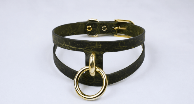 A dark green choker necklace with a gold-colored metal ring and buckle.