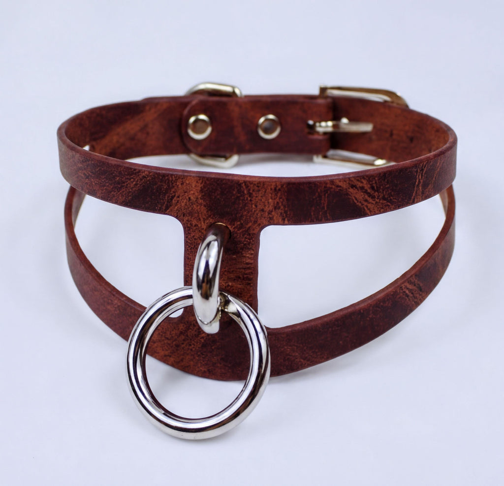 A brown leather choker necklace with a metal ring and buckle.
