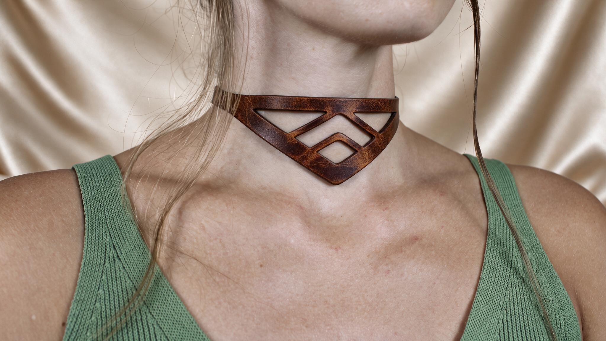 A close-up of a woman wearing a choker necklace with a geometric pattern.