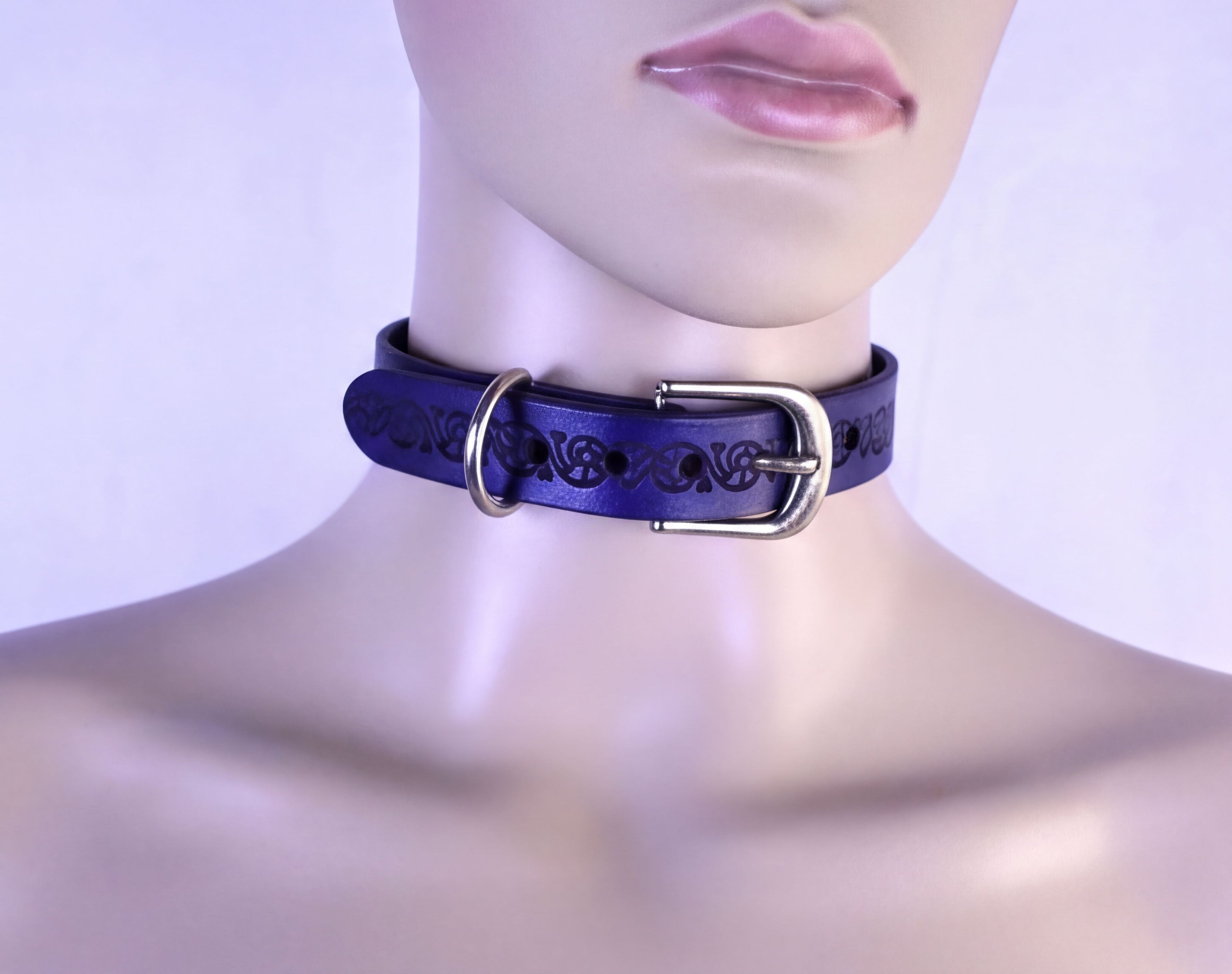 A mannequin head wearing a blue choker necklace with a metal buckle.