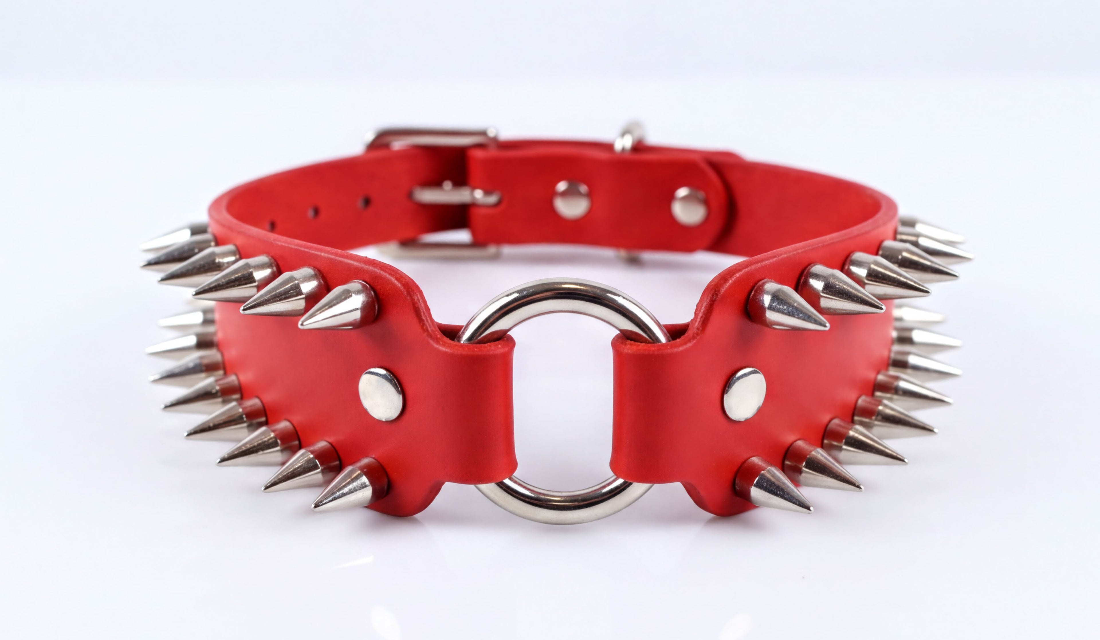 A red leather choker necklace with spikes protruding from it.