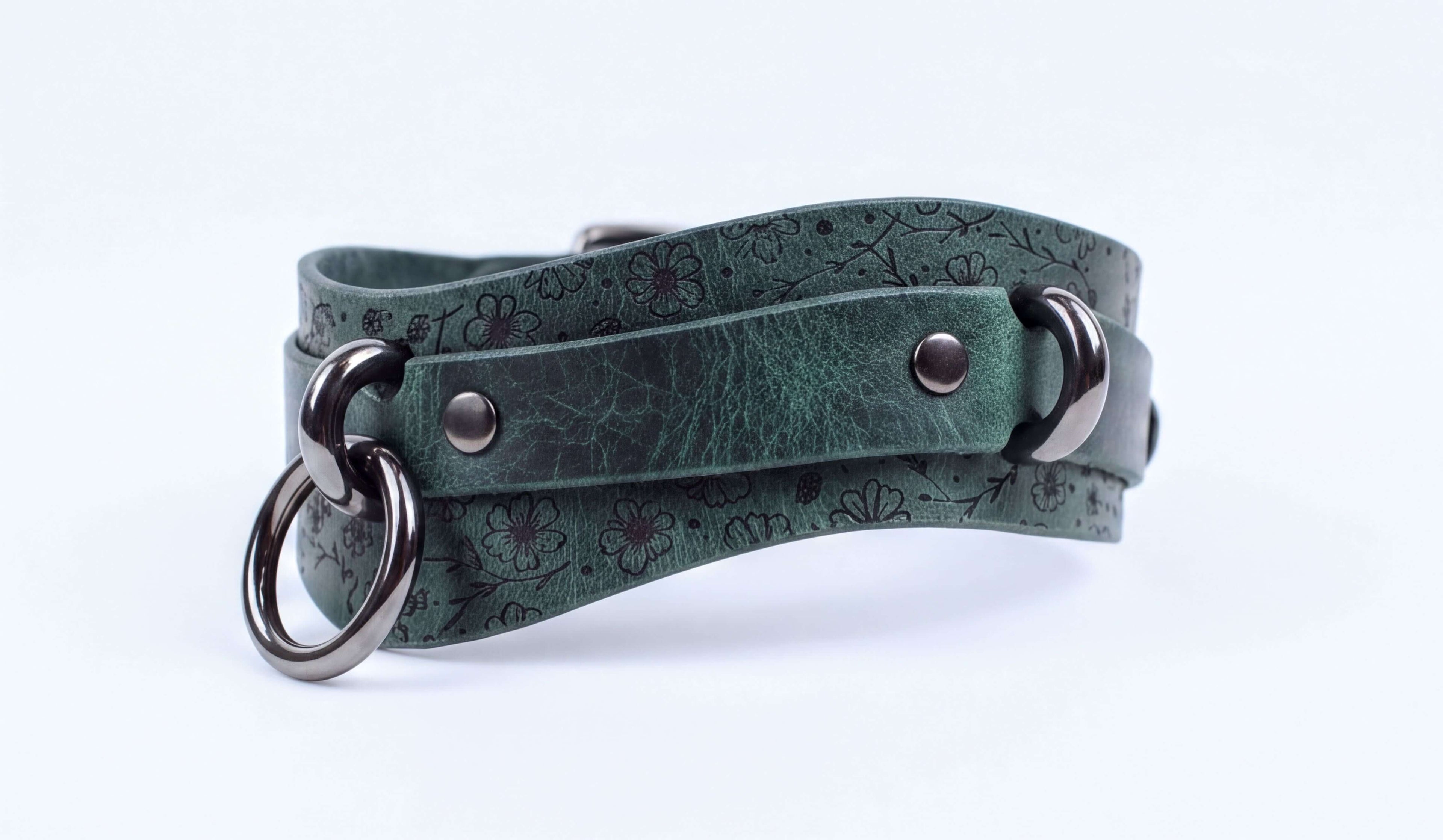A green leather choker necklace with metal rings and a metal clasp.