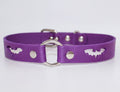 A purple leather dog collar with bat cutouts and metal rings.