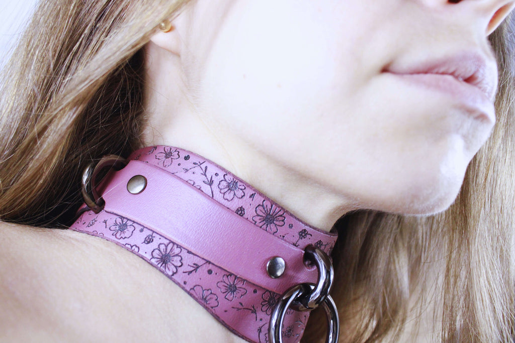 Floral Leather Sub Collar showcased on a model, featuring mauve leather with delicate floral patterns and metal accents.
