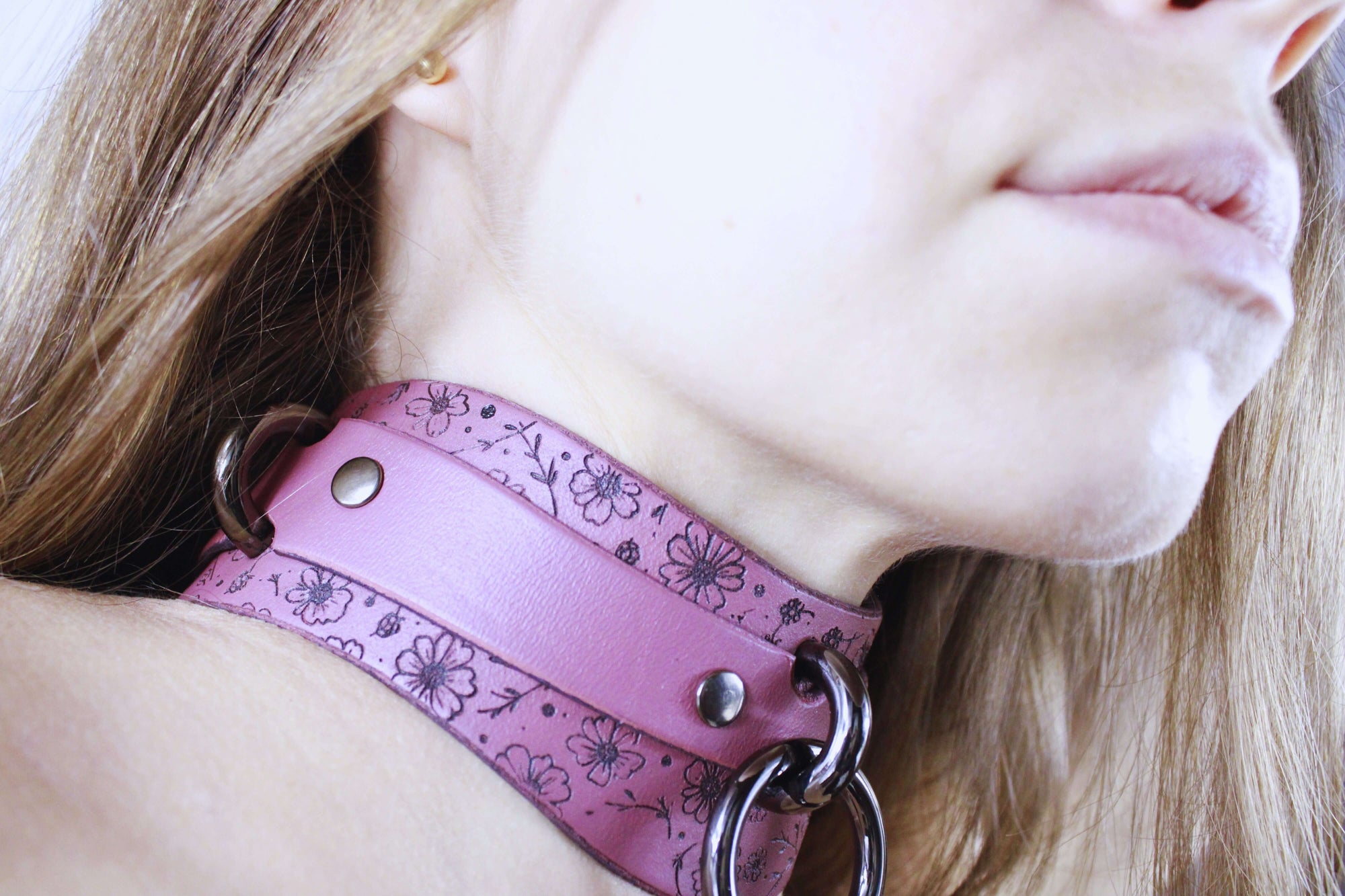 Floral Leather Sub Collar showcased on a model, featuring mauve leather with delicate floral patterns and metal accents.