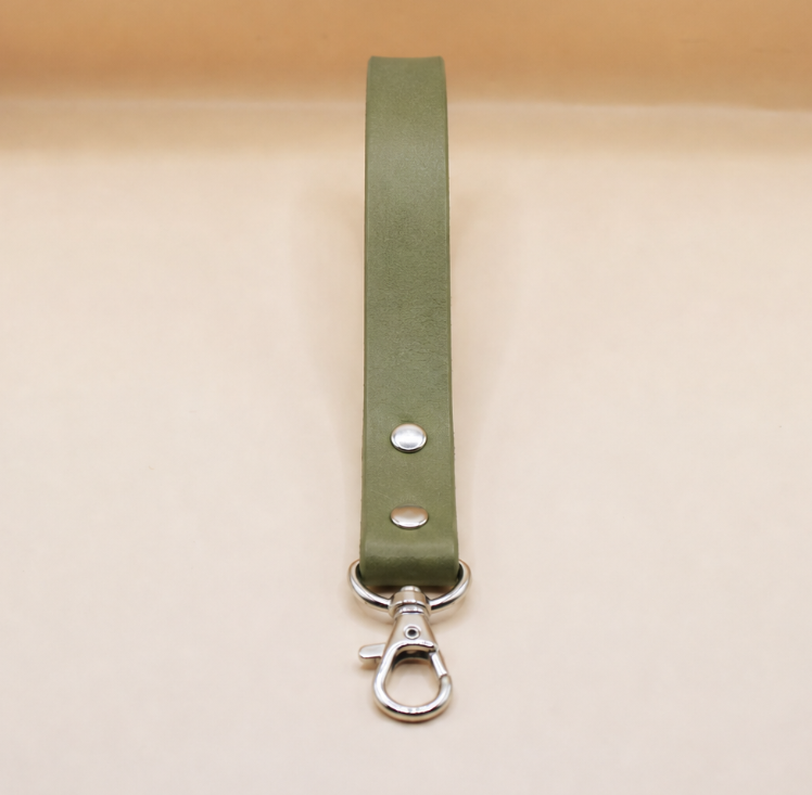 A green leather strap with a metal clasp and hook attached to it.