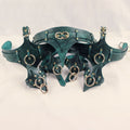 A collection of green leather straps with metal rings and buckles, arranged in a decorative manner.
