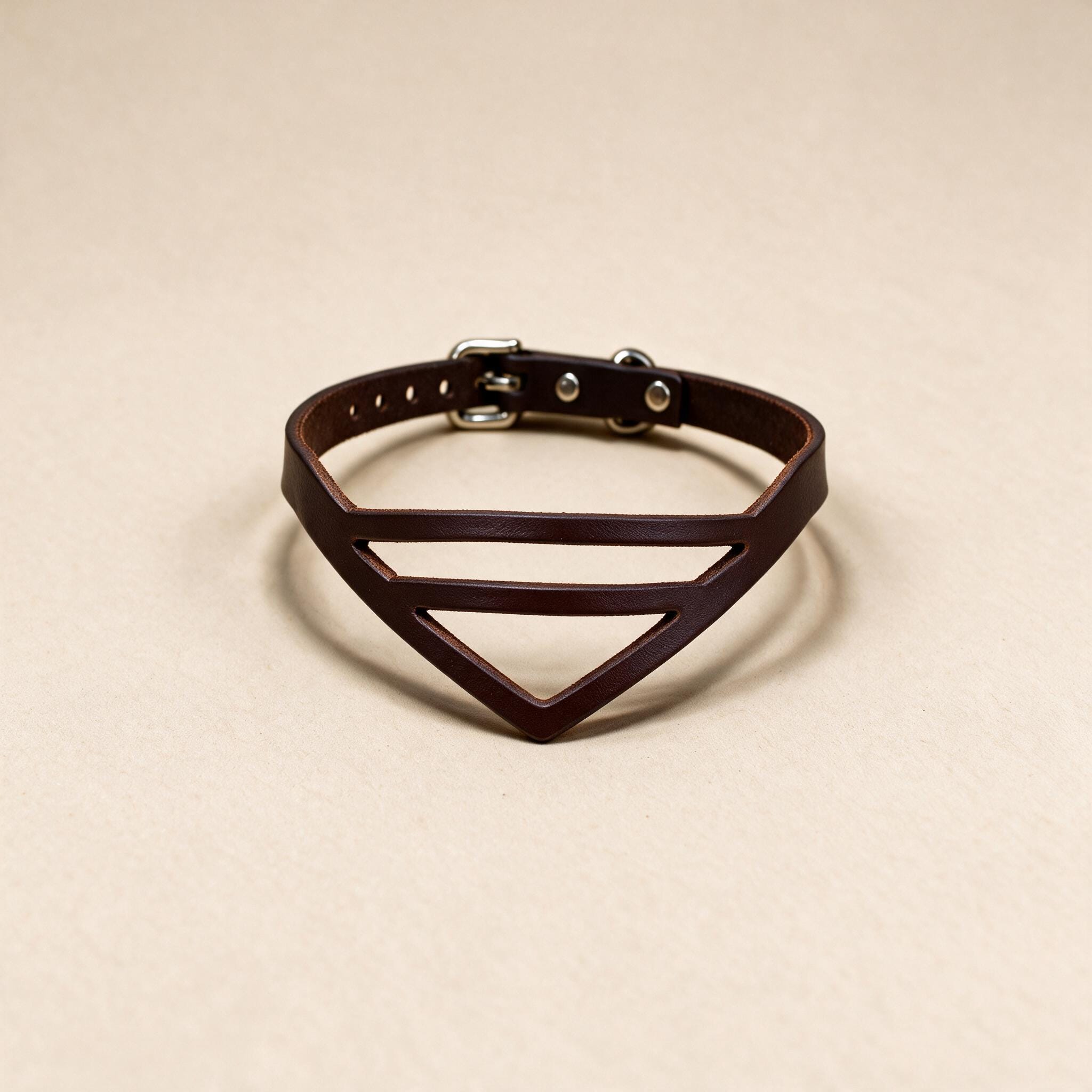 A brown leather choker necklace with a unique triangular design.