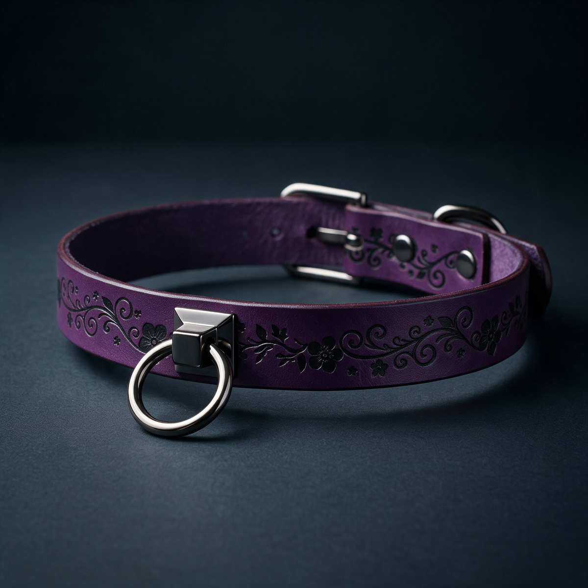 A purple leather collar with a metal ring and decorative floral patterns on the surface.