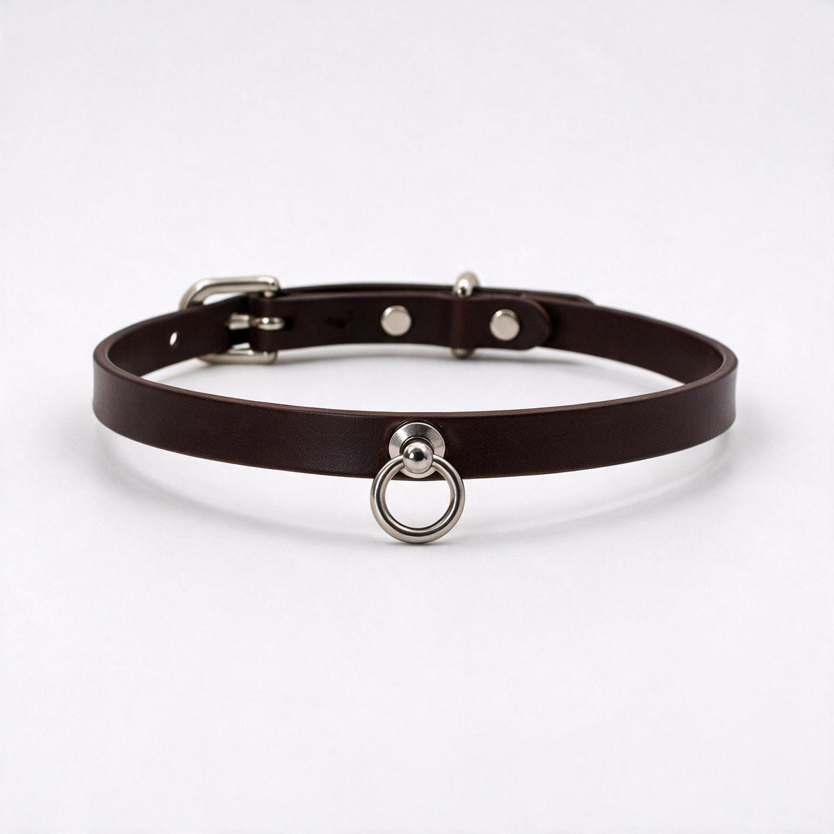 A brown leather choker collar with a metal ring and buckle.