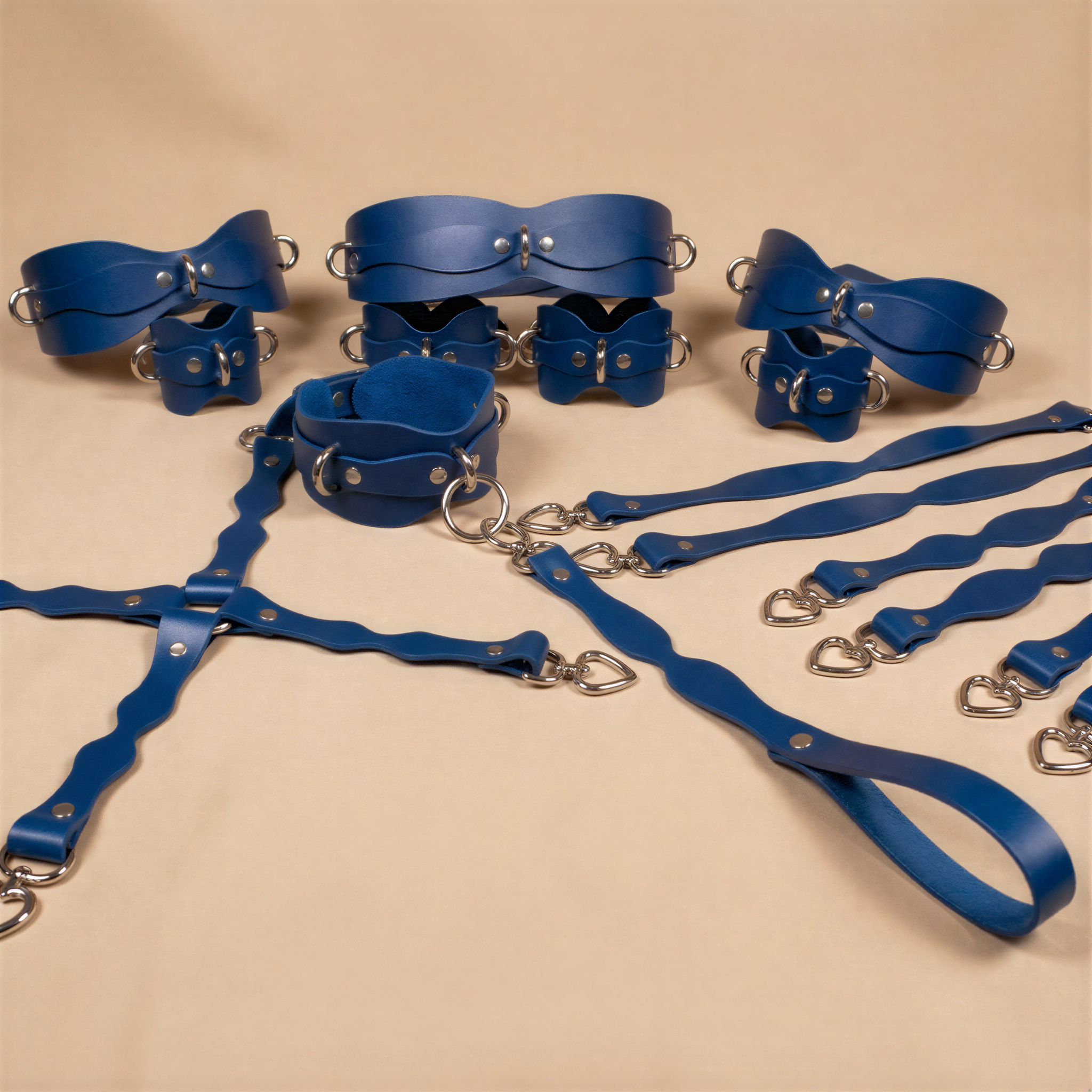 A collection of blue leather straps and buckles arranged on a beige background.