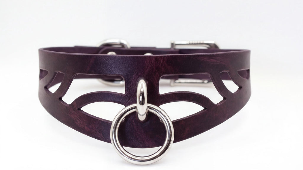 A close-up view of a dark purple leather choker necklace with a silver ring and buckle.