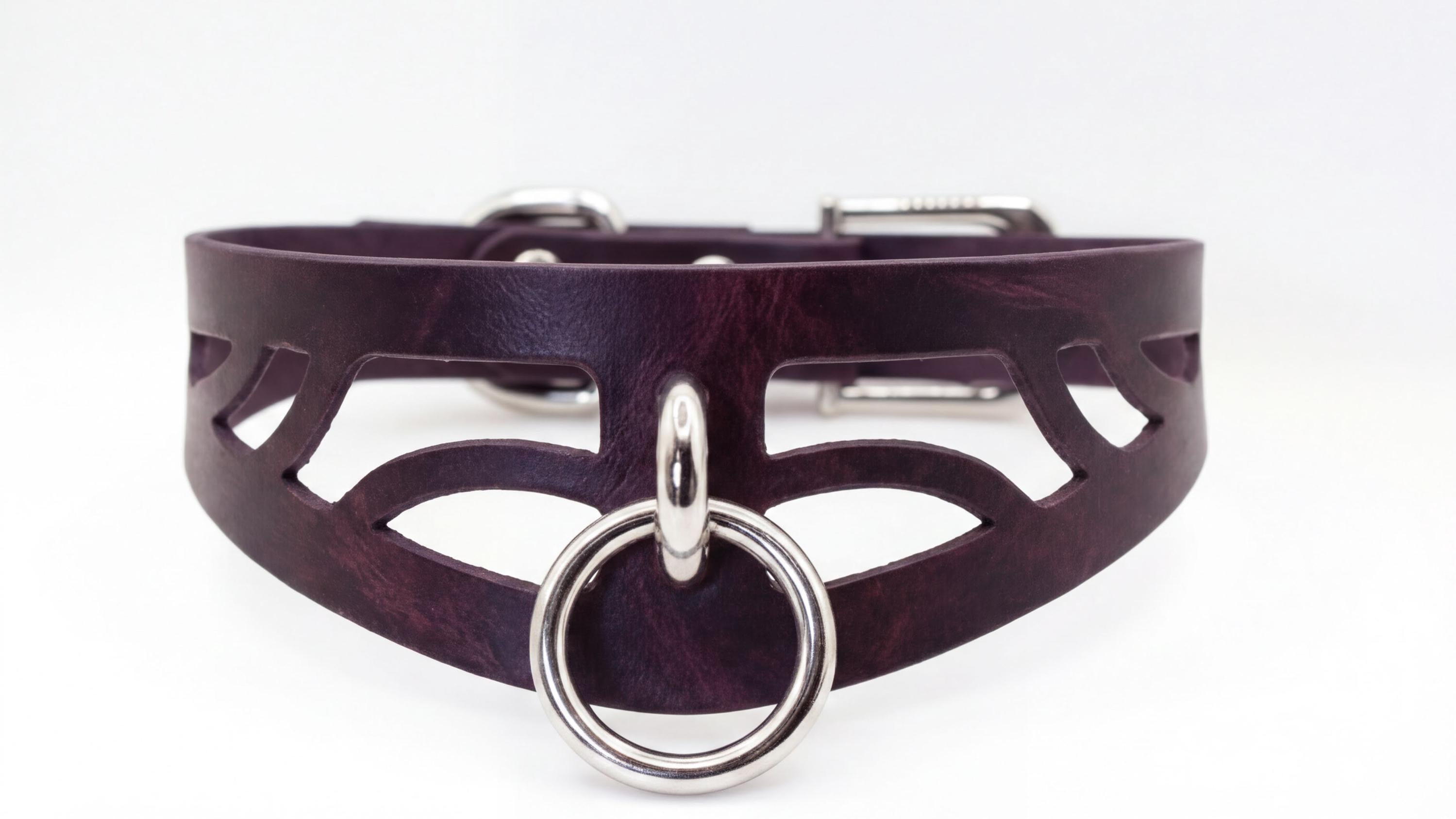 A close-up view of a dark purple leather choker necklace with a silver ring and buckle.