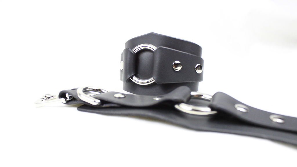 A black leather strap with metal rings and buckles is shown in the image.