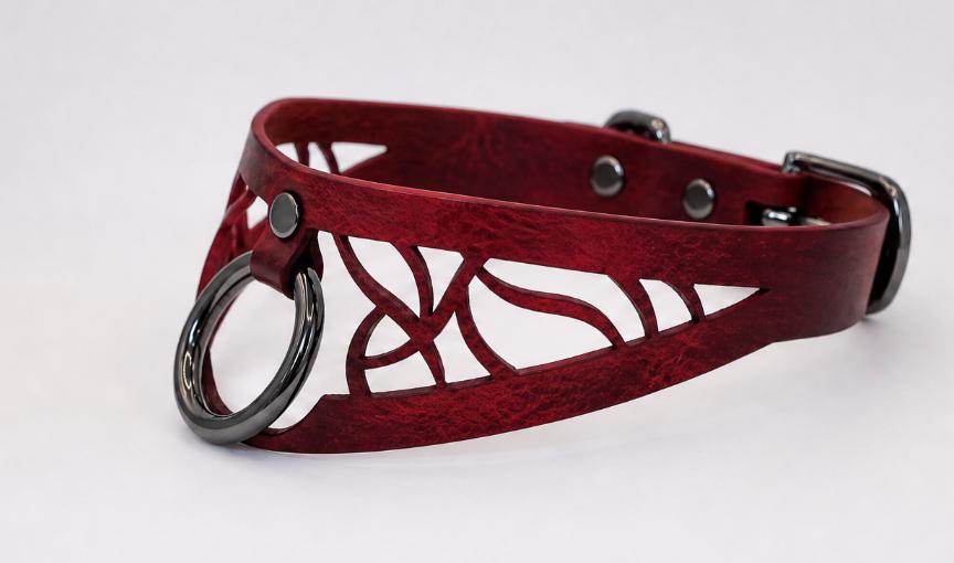 A red leather choker collar with a metal ring and cutout design.