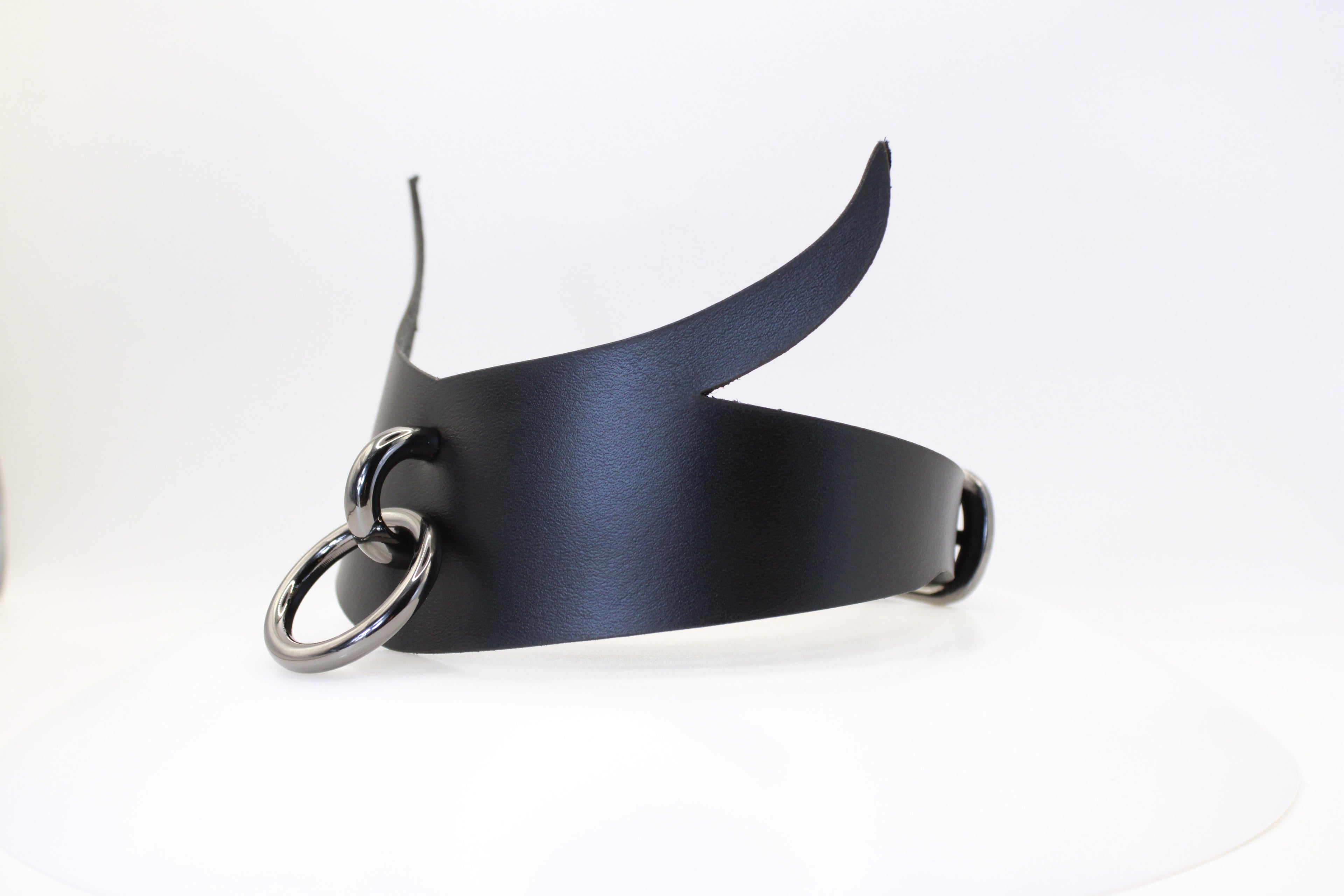 A black leather choker necklace with a metal ring and a curved horn-like element.