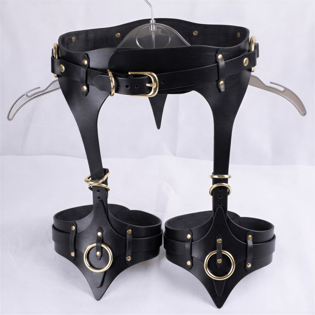 A pair of black leather garter belts with gold-colored buckles and rings, displayed on a white background.