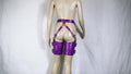 A mannequin wearing purple leather garter belts and garter cuffs against a white background.