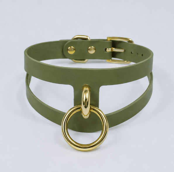 A green choker necklace with a gold-colored metal ring attached to it.