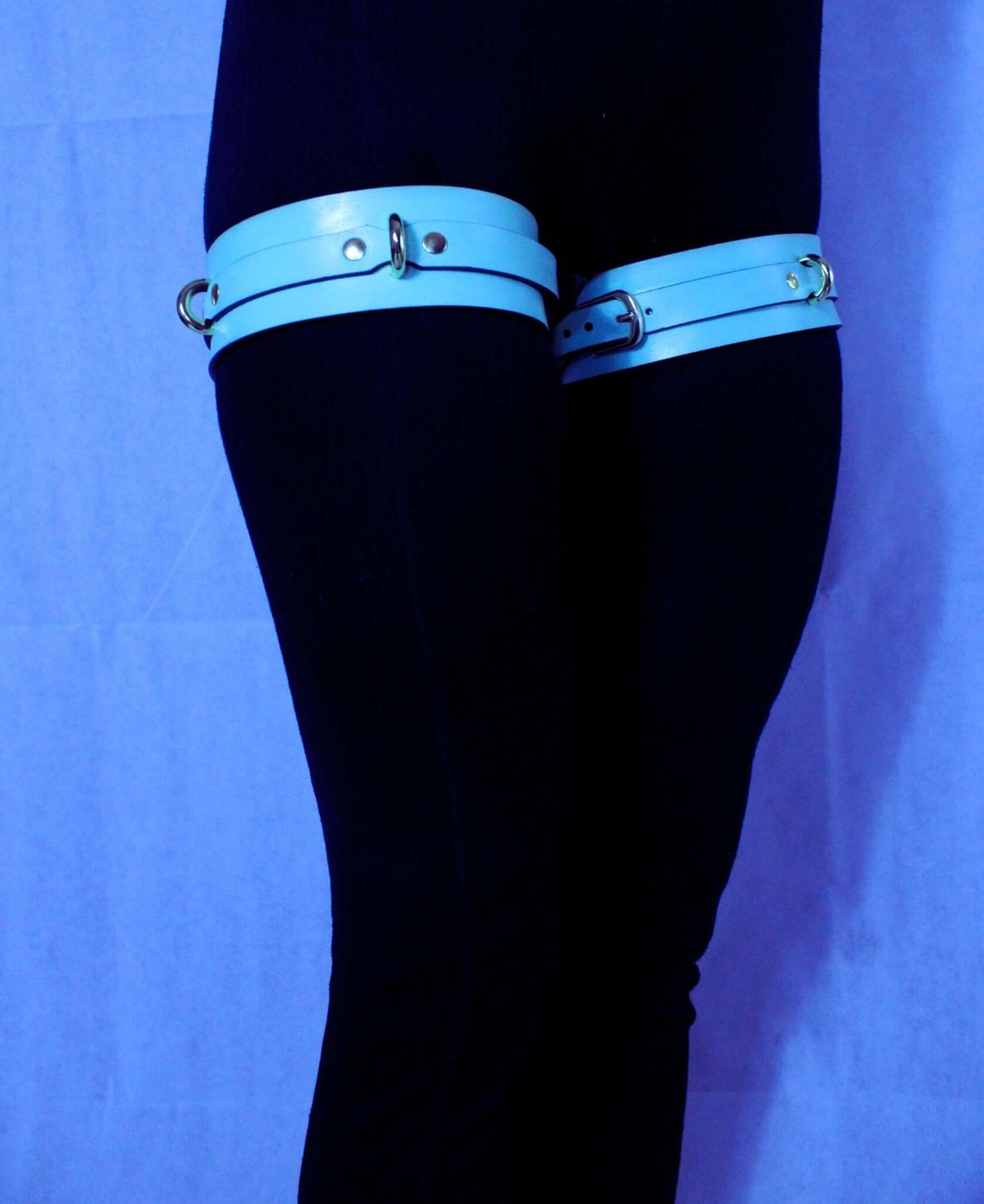 Adjustable blue leather thigh cuffs for BDSM, bondage gear, submissive play, and erotic lingerie.