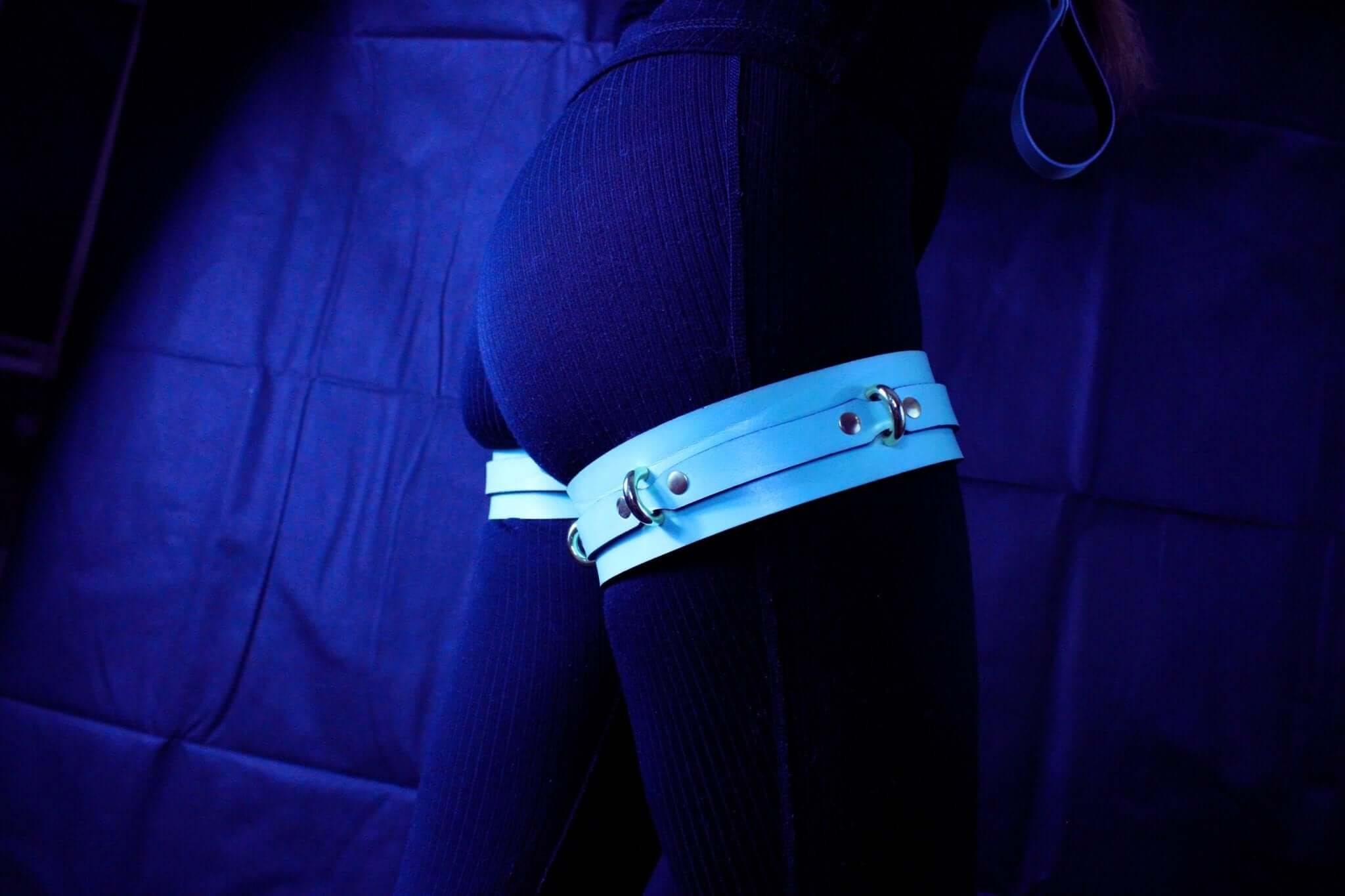 Adjustable blue leather thigh cuffs for bondage, enhancing submissive experiences and stylish restraint gear.