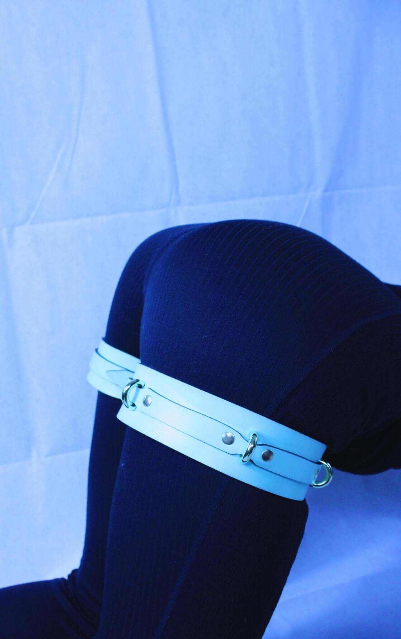 Adjustable leather thigh cuffs on a model, ideal for BDSM, bondage play, and enhancing submissive experiences.