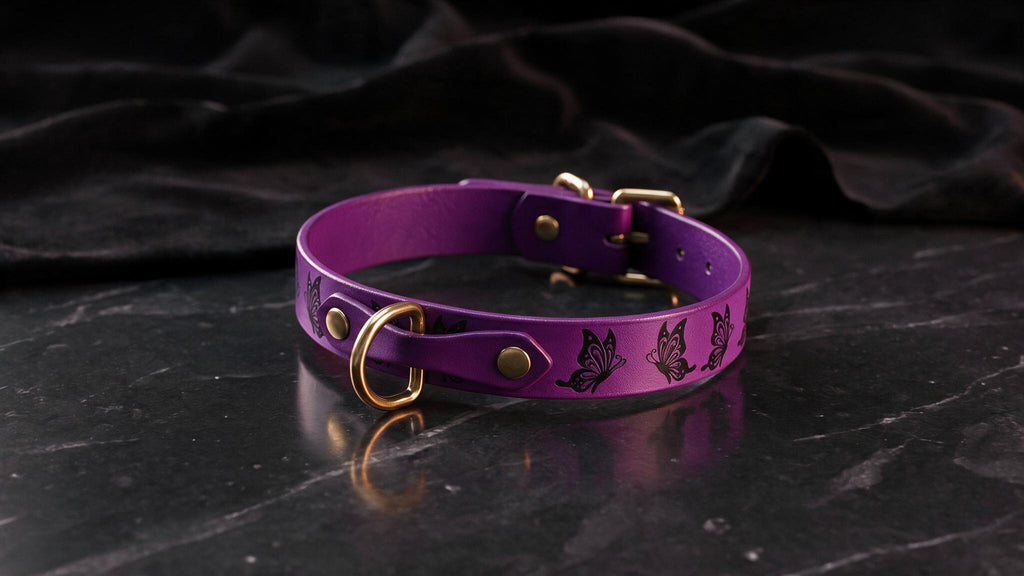 A purple leather collar with gold accents and butterfly designs is displayed on a black marble surface.