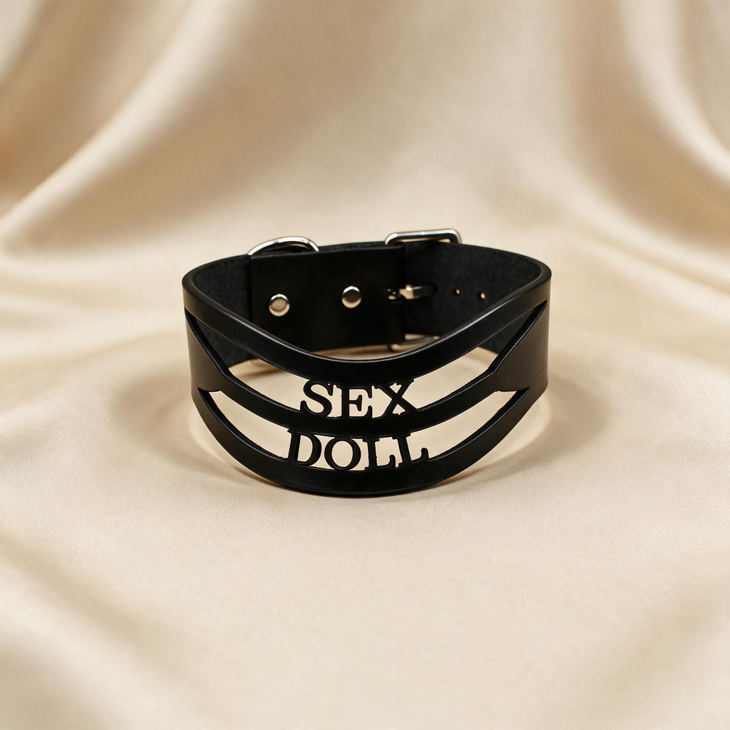 A black leather choker necklace with the text "SEX DOLL" printed on it.