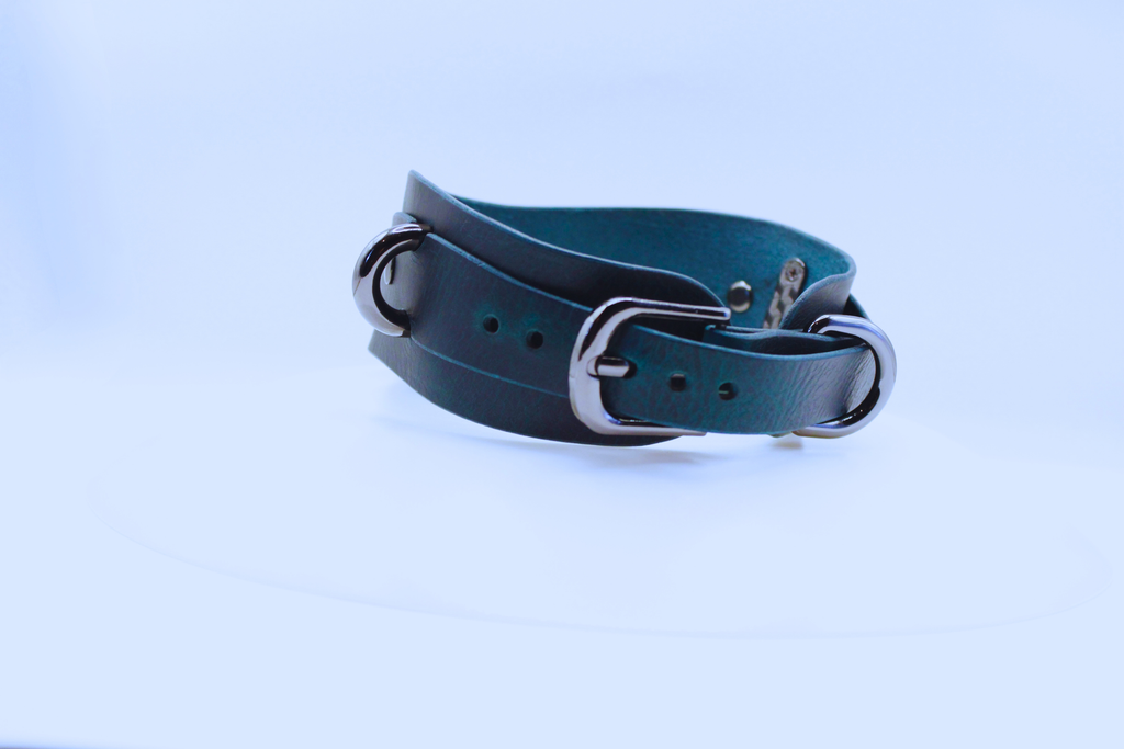 A dark blue leather belt with silver buckles is shown against a white background.