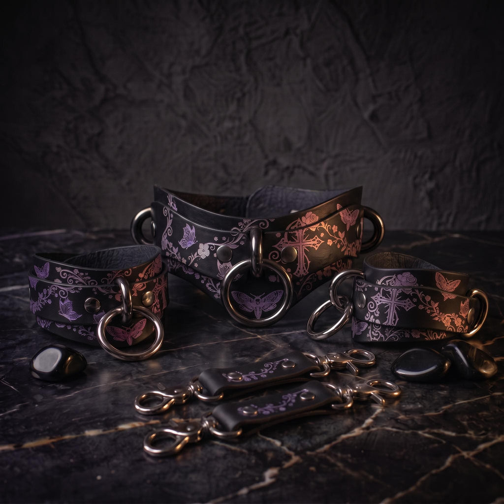 a collection of leather straps and charms with floral and butterfly designs, arranged on a dark surface.