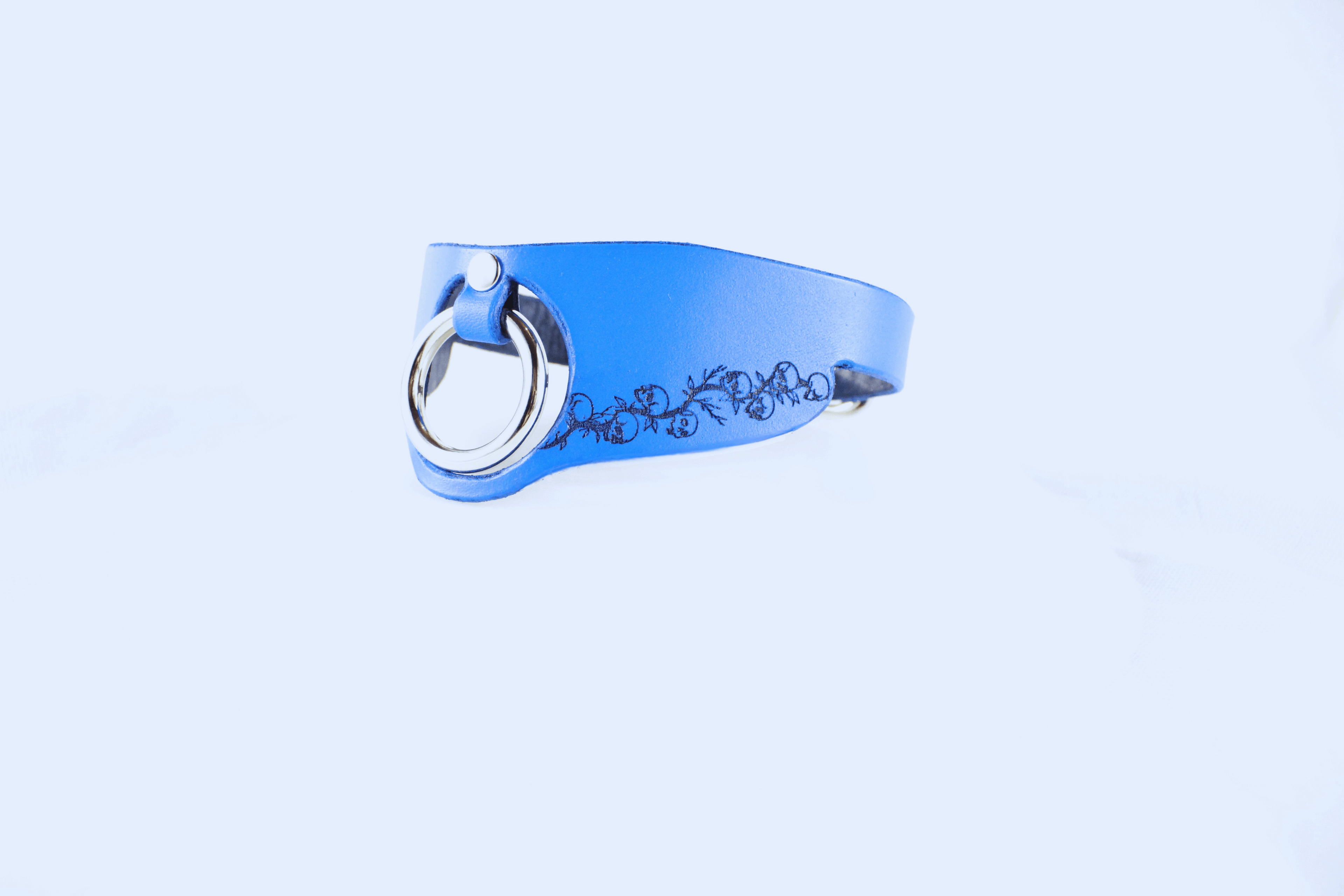 Blue leather submissive collar with floral pattern, featuring a metal ring, perfect for discreet day wear.