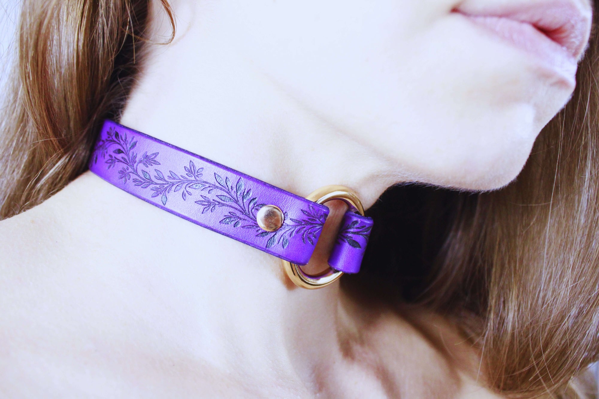 Leaf Pattern Submissive Day Collar in purple leather worn as discreet jewelry around the neck.
