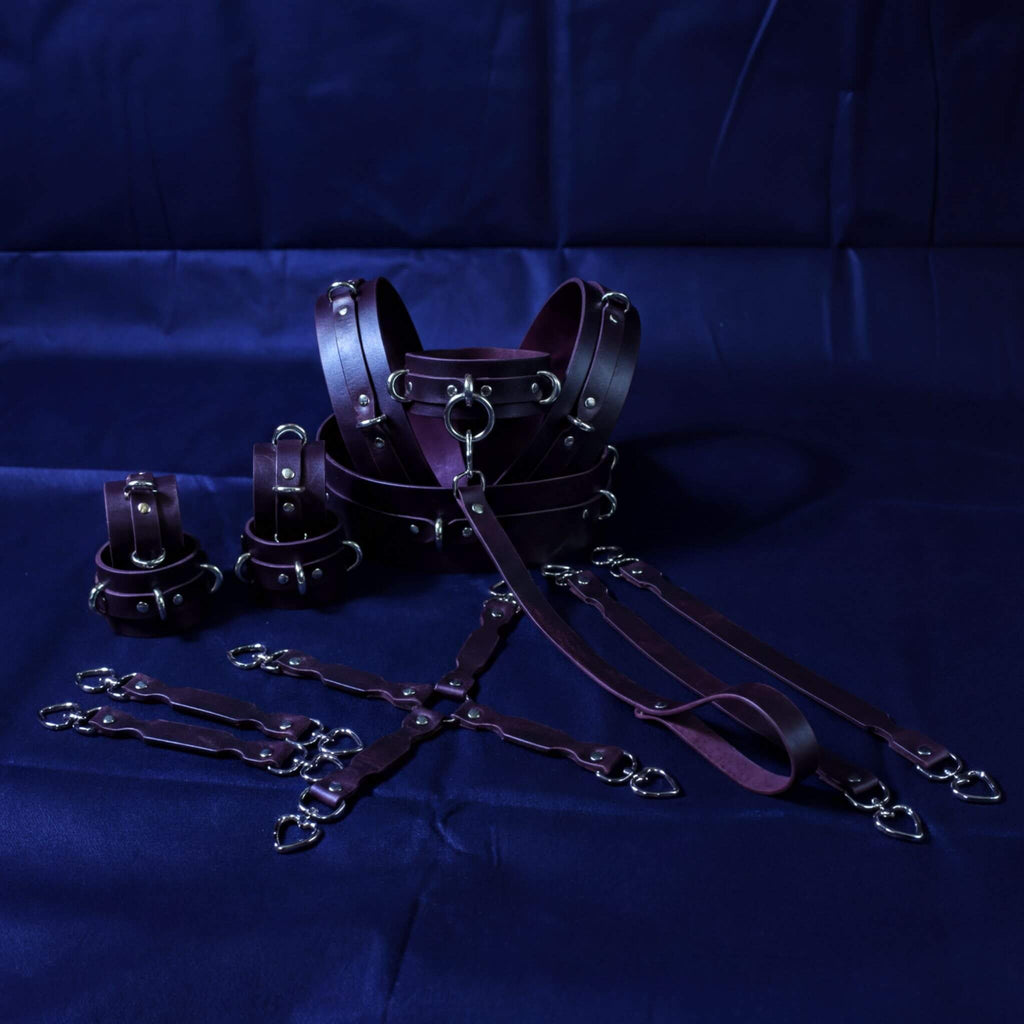 a collection of leather straps and buckles in various sizes and shapes, arranged on a dark blue background.