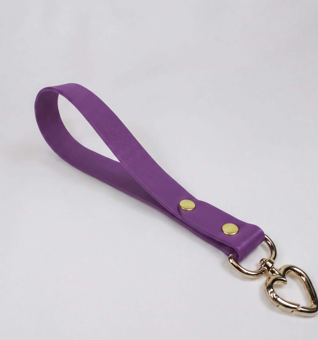 A purple leather strap with a heart-shaped metal clasp attached to it.