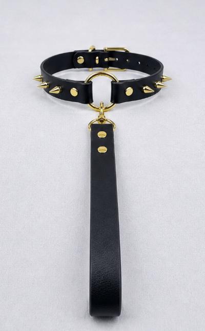 A black leather choker necklace with gold studs and a black handle attached to it.