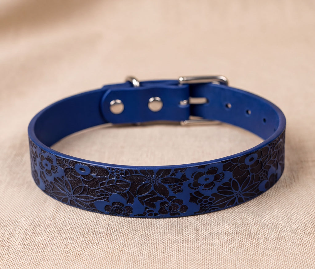 A blue dog collar with a floral pattern on it.