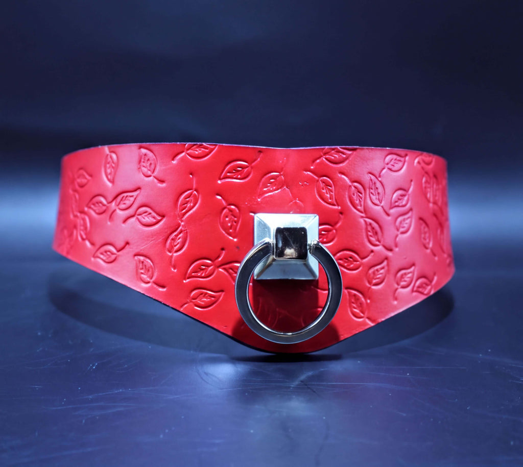 A red leather choker necklace with a silver metal ring and leaf pattern design.