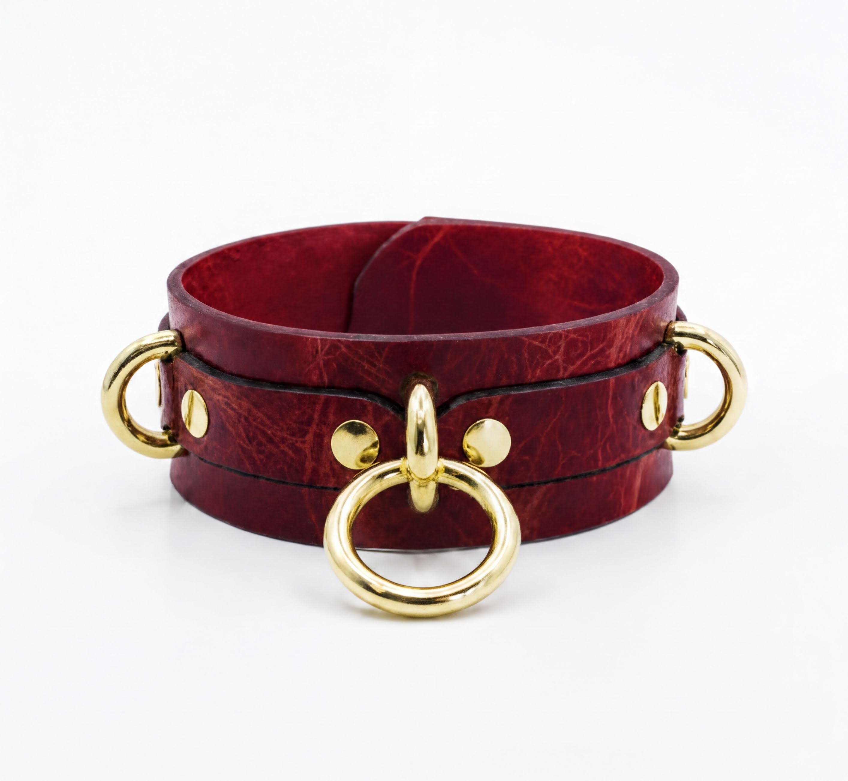 A burgundy leather choker necklace with gold metal rings and buckles.