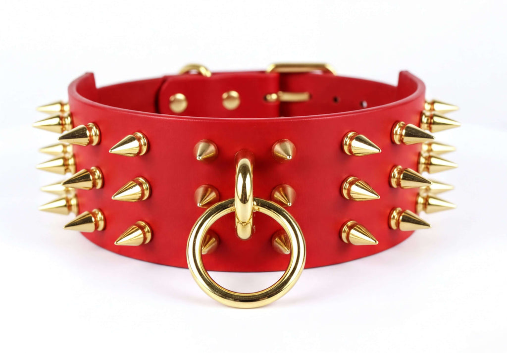 A red leather choker necklace with gold spikes protruding from it.
