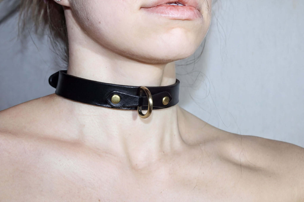 Minimalist black leather choker collar for discreet daywear, perfect for submissive jewelry and BDSM styles.