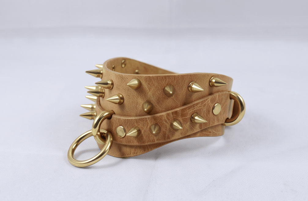 A leather strap with gold spikes and rings, creating a bold and edgy accessory.