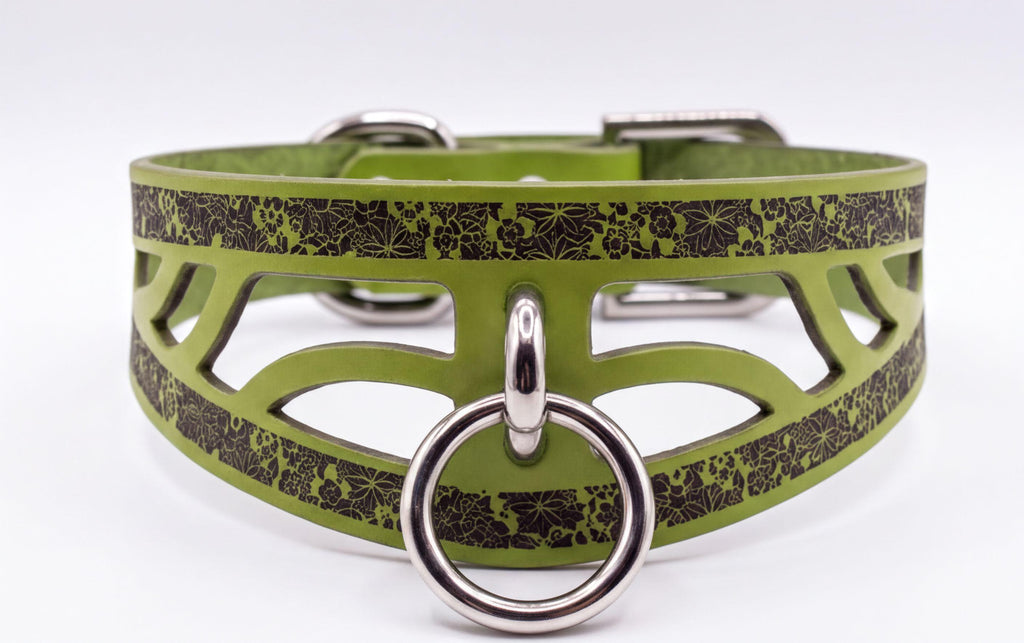 A green leather collar with a metal ring and a floral pattern on the front.