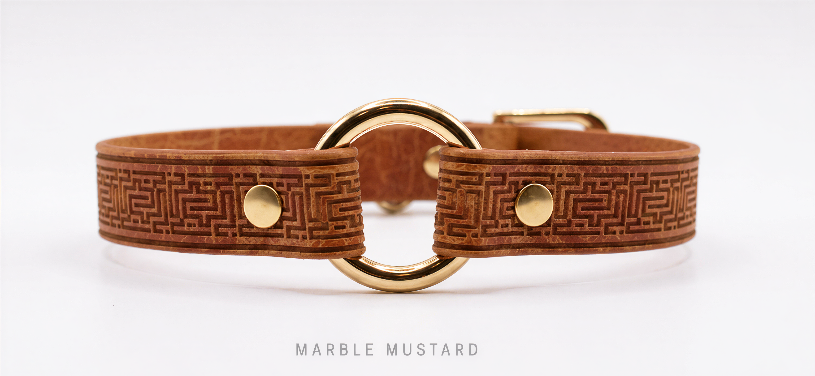 A brown leather collar with a gold metal buckle and a marble mustard pattern.